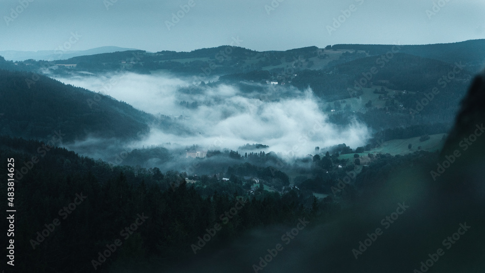 Czech typical autumn landscape with rock infront of capture. Hills and forest with foggy morning. Morning fall valley of Podkrkonosi, wild Europe.