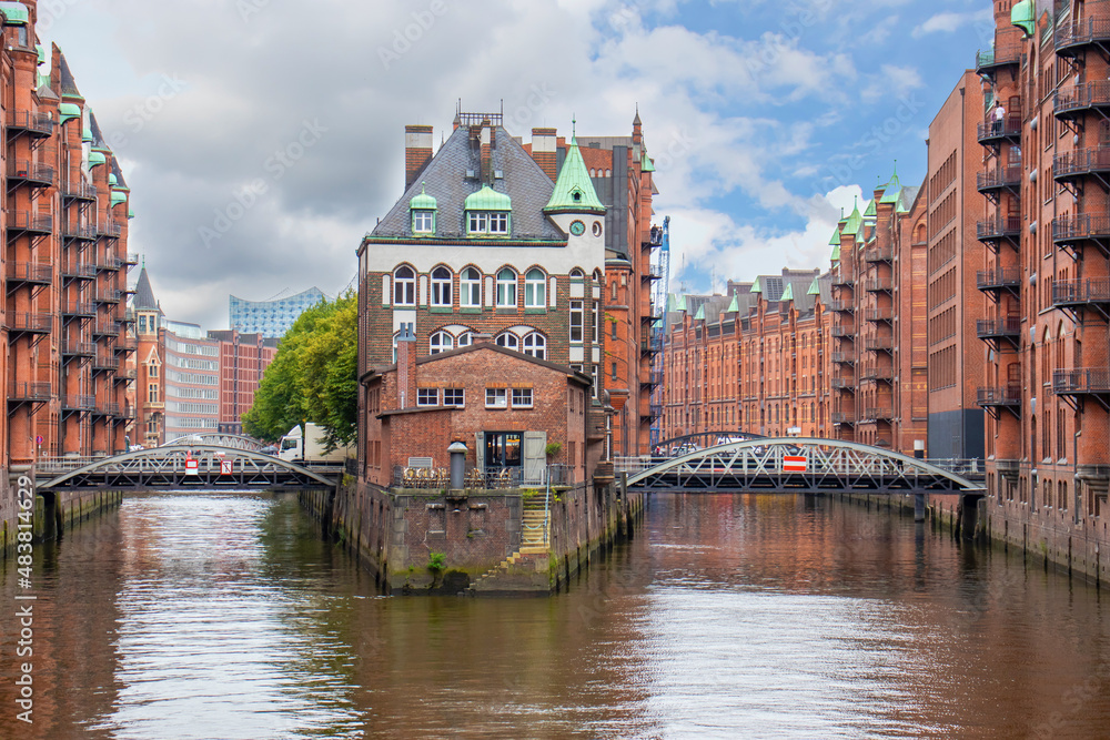 Hamburg, German. View of famous Speicherstadt warehouse district. Old brick building, river canal of Hafencity quarter. Hamburg skyline.