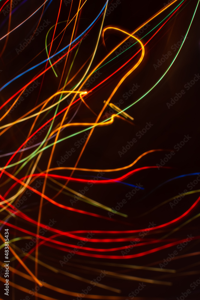 Drawing with light. Abstract multicolored rays on a black background. Curved wave lines. Drawing with light. Abstract multicolored rays on a black background. Curved wave lines.
