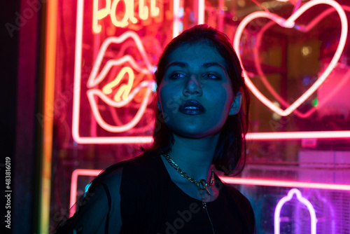 Neon close up portrait of young woman wear hoodie. night city street shot photo