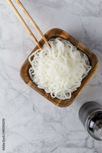 White shirataki noddle on white background with soy sauce . Konjac low carb pasta .