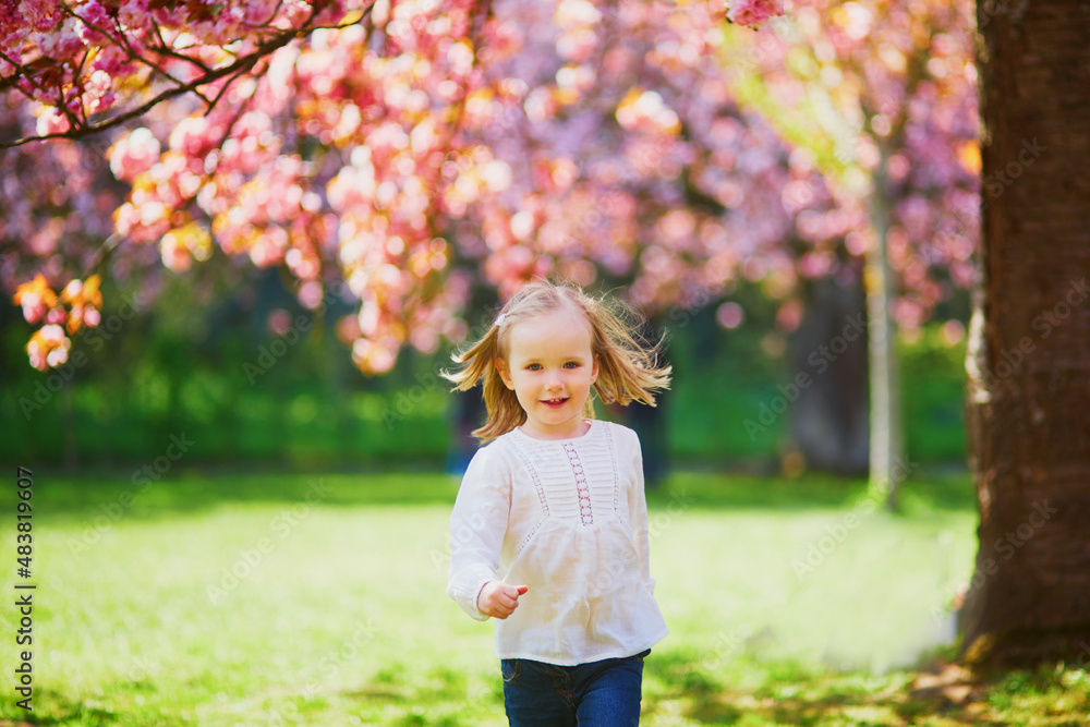 Adorable three year old girl enjoying sunny spring day in Park of Sceaux near Paris, France Adorable three year old girl enjoying sunny spring day in Park of Sceaux near Paris, France