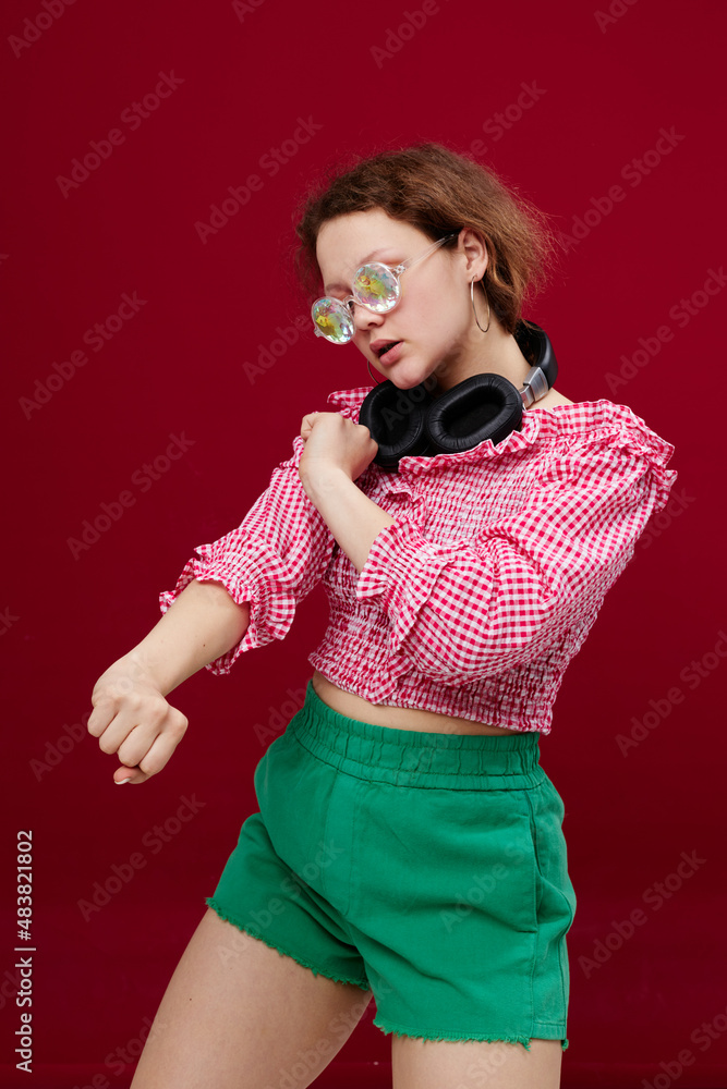 Obraz premium portrait of a girl in green shorts glasses with diamond headphones posing