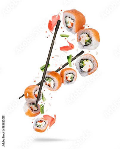 Fresh sushi with red fish and ingredients in the air isolated on white background