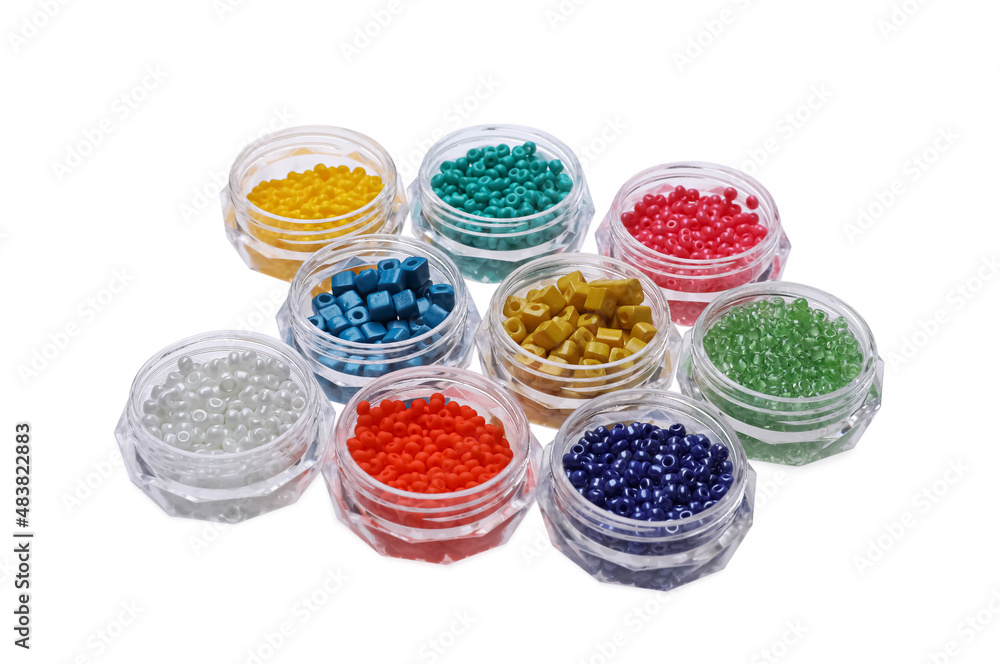 Plastic containers with different beads on white background Plastic containers with different beads on white background