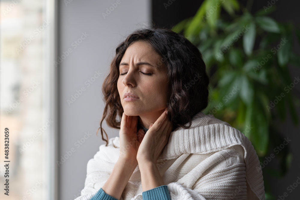 Sick woman suffer from sore throat touch enlarged lymph nodes staying home on sick leave. Unhappy young female with coronavirus disease, angina or pharyngitis illness symptoms. Girl feeling discomfort Sick woman suffer from sore throat touch enlarged lymph nodes staying home on sick leave. Unhappy young female with coronavirus disease, angina or pharyngitis illness symptoms. Girl feeling discomfort