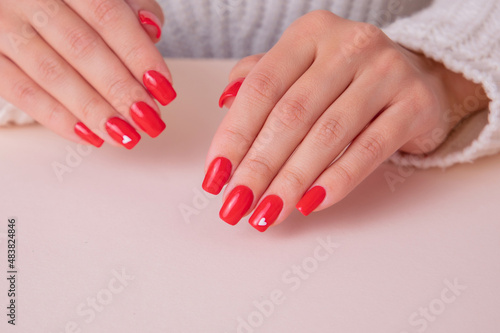 Beautiful female hands with red manicure nails, hearts and Valentine's day design