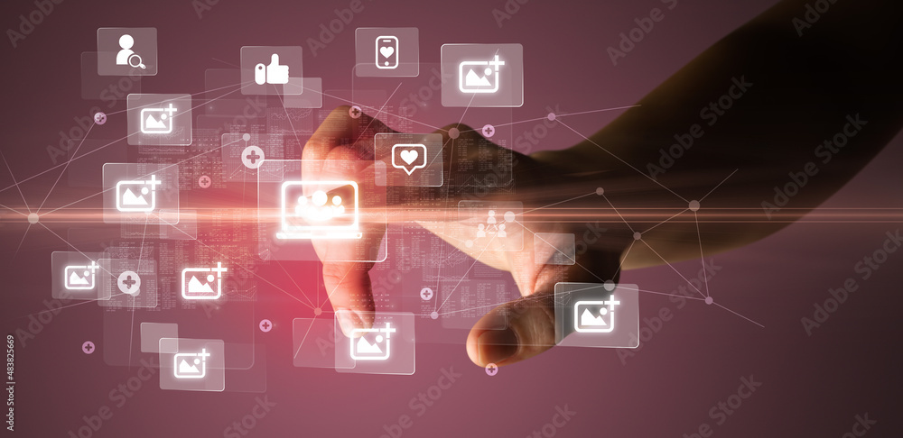 Hand pressing social media multimedia application screen with media icons on futuristic concept Hand pressing social media multimedia application screen with media icons on futuristic concept
