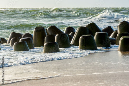 Storm on the North Sea, waves hitting the breakwater concrete tetrapods on the beach, Sylt, Germany photo
