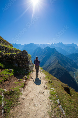 Late afternoon sun shines down on a teenage girl hiking the Inca Trail to Machu Picchu