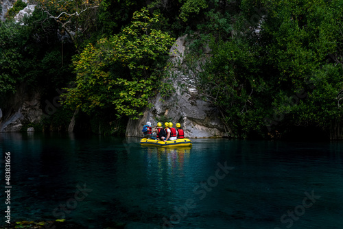 people on an inflatable boat rafting down the blue water canyon in Goynuk, Turkey