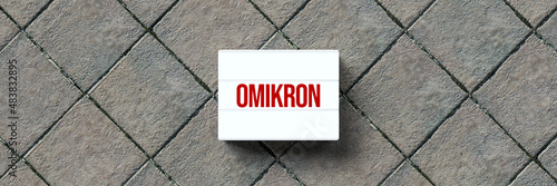 lightbox with message OMIKRON on stone pavement background