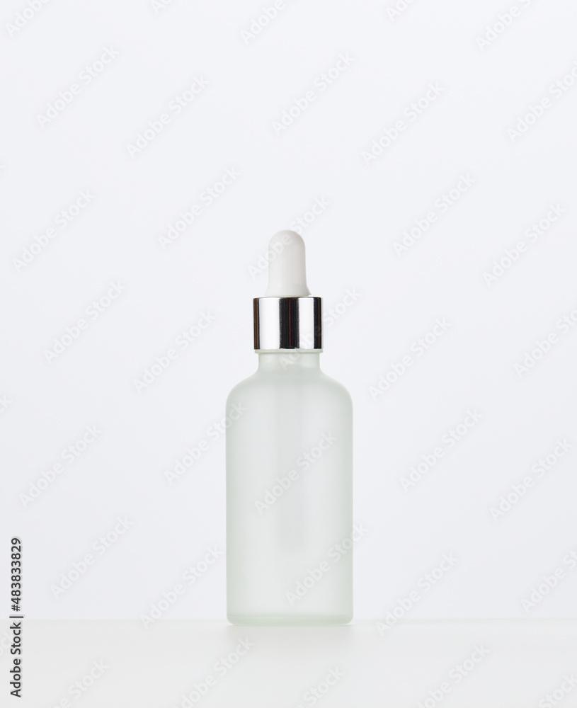 white glass bottle with a pipette on a white background. Template for cosmetic liquid products white glass bottle with a pipette on a white background. Template for cosmetic liquid products