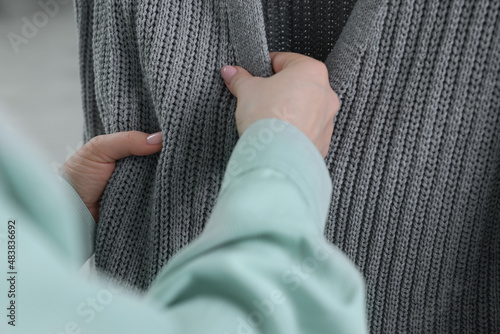 Woman touching clothes made of soft knitted fabric  closeup