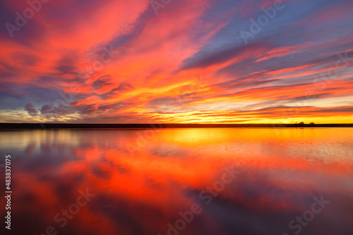 Colorful dramatic Sunrise over a Lake with the clouds reflecting in the water