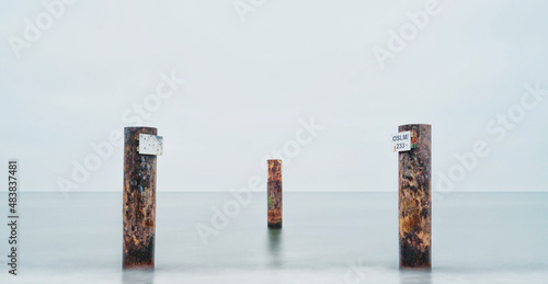 Holzpfähle im Wasser am Strand