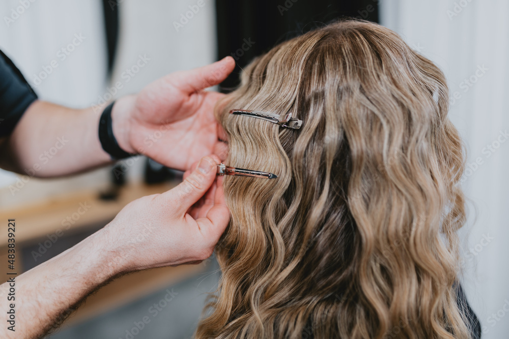 Fototapeta premium Beautiful hairstyle of young blond woman after dyeing hair and making highlights in hair salon.