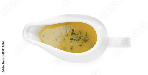 Ceramic sauce boat with lemon salad dressing on white background, top view