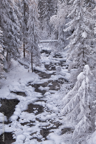 Photo of frozen river Pescherka near waterfall in winter. Siberia, Russia
