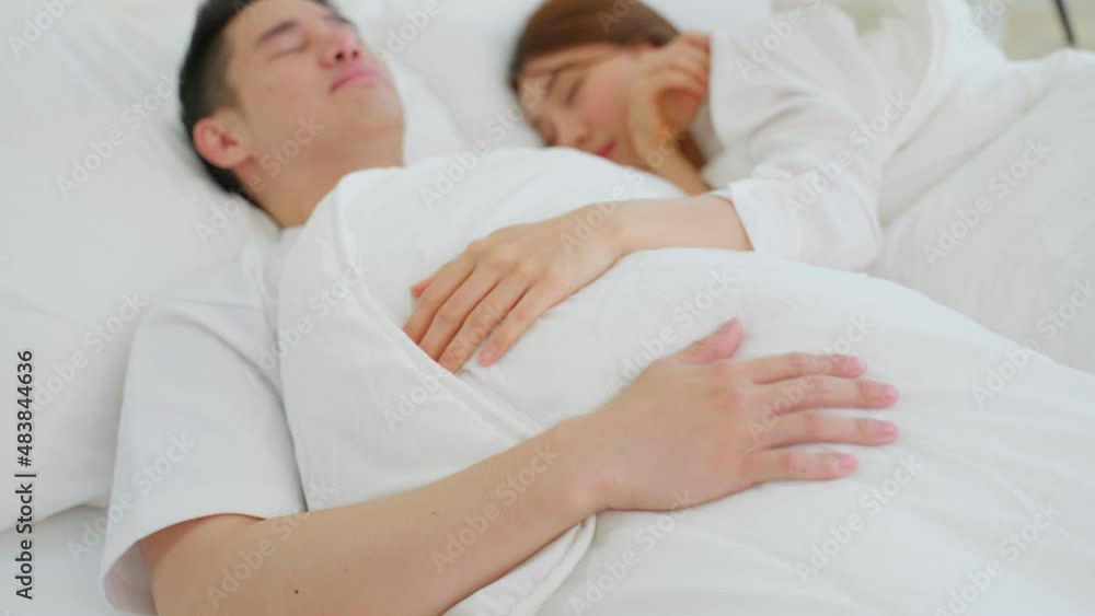 Asian attractive young couple lying down on bed to sleep in bedroom. Asian attractive young couple lying down on bed to sleep in bedroom.
