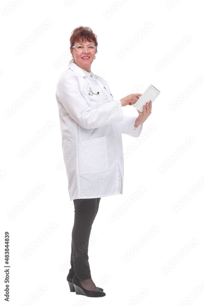Side view of senior woman doctor with stethoscope write on tablet looking at camera