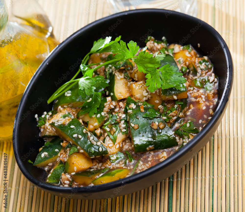 Salad of broken cucumbers with sesame seeds, sugar, red and black pepper, olive oil. High quality photo