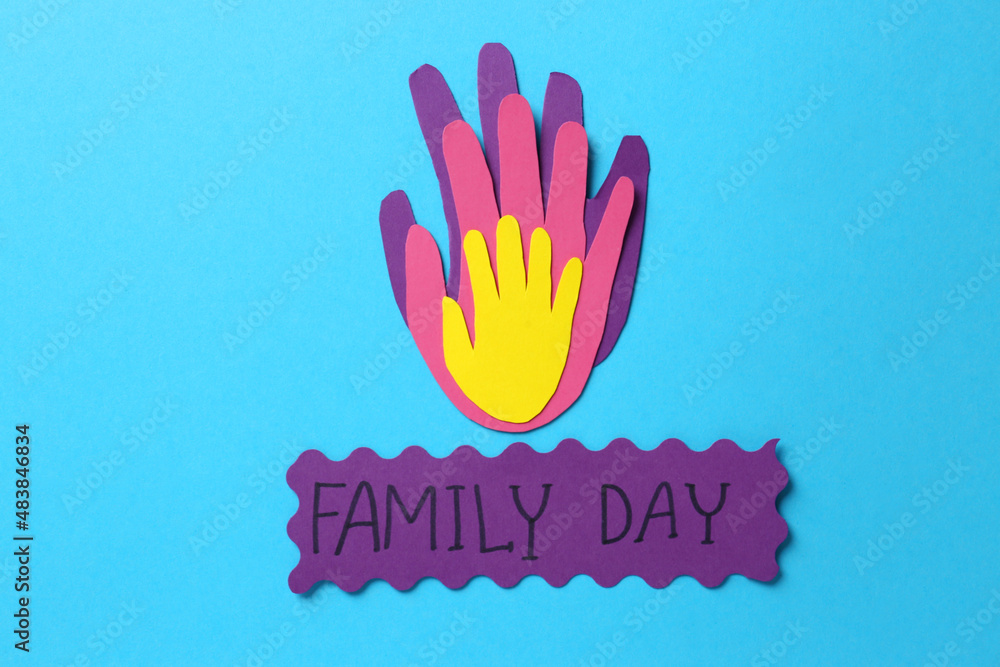Card with text Family Day and paper palms on light blue background, flat lay Card with text Family Day and paper palms on light blue background, flat lay