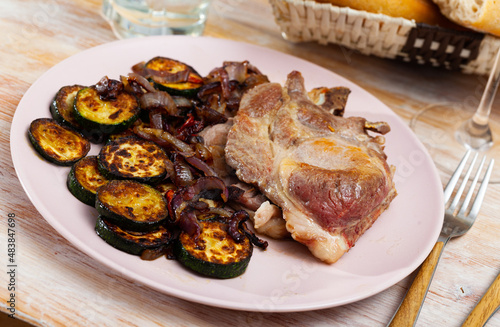 Appetizing grilled pork loin chops with courgette and onions