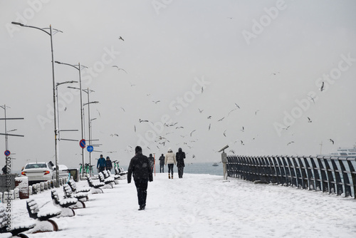 Magnific view of coastline in Uskudar, Istanbul,Turkey. People walking near Bosphorus in winter day with many snow. Istanbul's main attractions. © Ersin