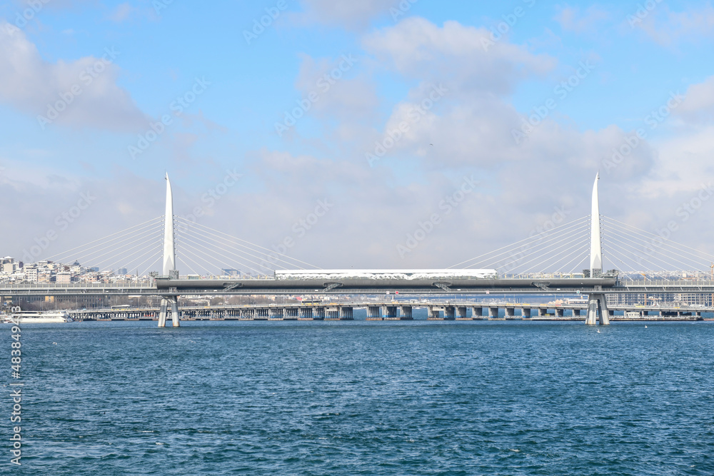 Panoramic view of Golden Horn Metro Bridge during cold winter day with many snow. Istanbul. Turkey.