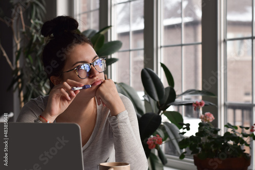 Fotografía Young girl student in glasses sitting at desk in deep thought