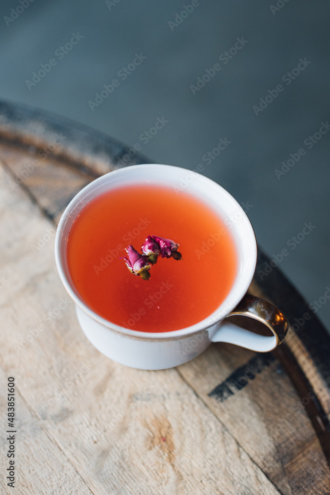 red tea with rosebuds on wood barrel red tea with rosebuds on wood barrel