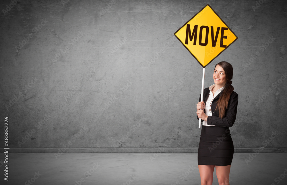 Young business person holding road sign Young business person holding road sign