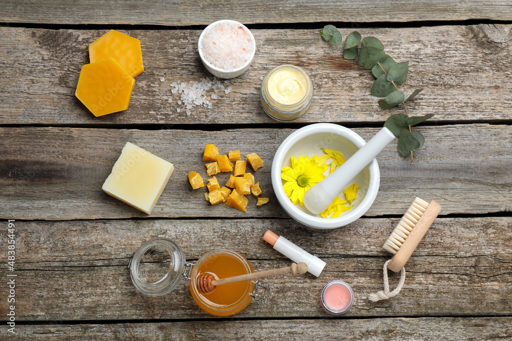 Flat lay composition with beeswax and cosmetic products on wooden table Flat lay composition with beeswax and cosmetic products on wooden table