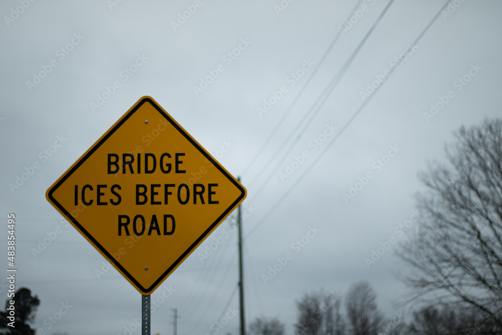 A yellow bridge ices before the road sign A yellow bridge ices before the road sign