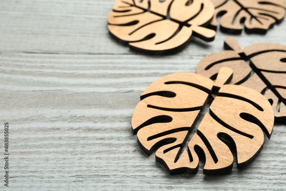 Leaf shaped wooden cup coasters on light grey table, space for text Leaf shaped wooden cup coasters on light grey table, space for text