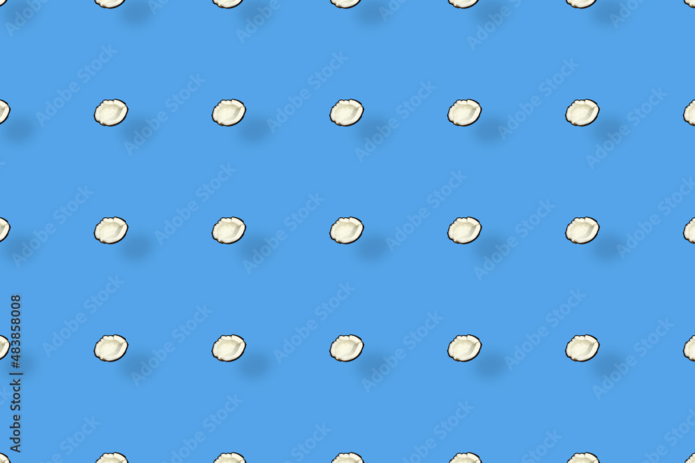 Colorful pattern of coconuts on blue background with shadows. Top view. Flat lay. Pop art design