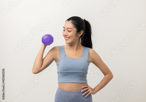 Sporty Asian woman exercises with dumbbells on isolated white background. Good shape and health fitness woman weight training standing pose smile to camera.