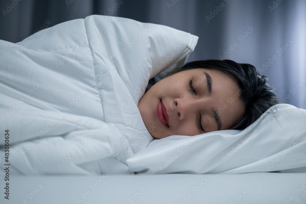 Beautiful asian woman lying in the bed at night. Young woman sleeping well in comfortable cozy fresh bed on soft pillow white linen. Health and rest concept. Beautiful asian woman lying in the bed at night. Young woman sleeping well in comfortable cozy fresh bed on soft pillow white linen. Health and rest concept.
