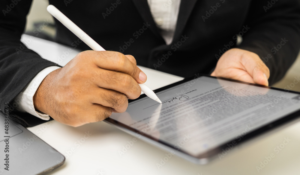 Close up businessman hand electronic Signature on Tablet by Stylus. Write business agreement of contract. Man signing contract on tablet. Business and technology concept. - obrazy, fototapety, plakaty 