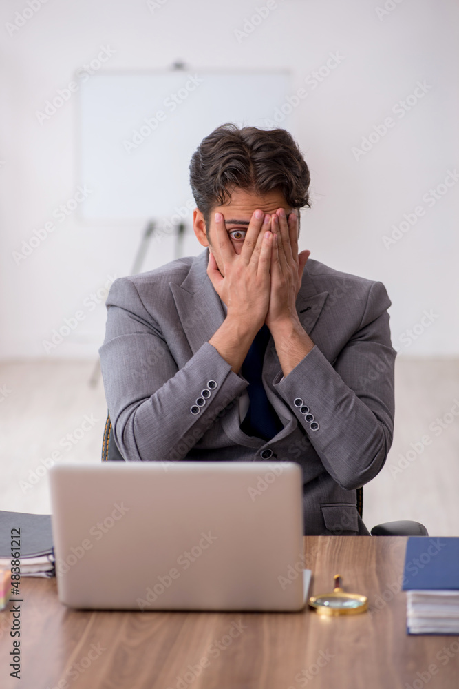 Young male employee sitting in the office Young male employee sitting in the office