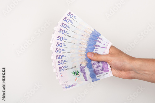 Hand holding colombian money photo