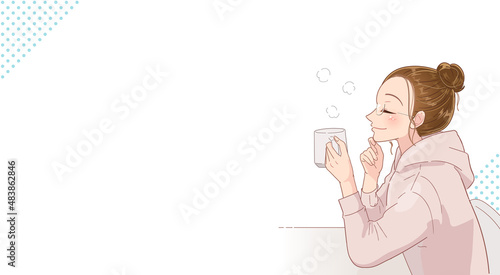 コップで飲み物を飲みながらリラックスする若い女性