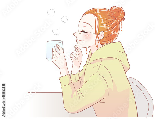 コップで飲み物を飲みながらリラックスする若い女性