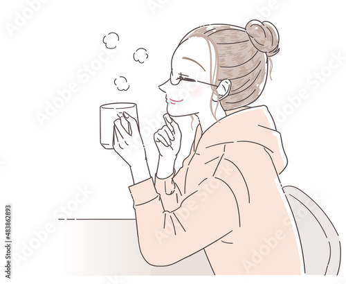 コップで飲み物を飲みながらリラックスする若い女性