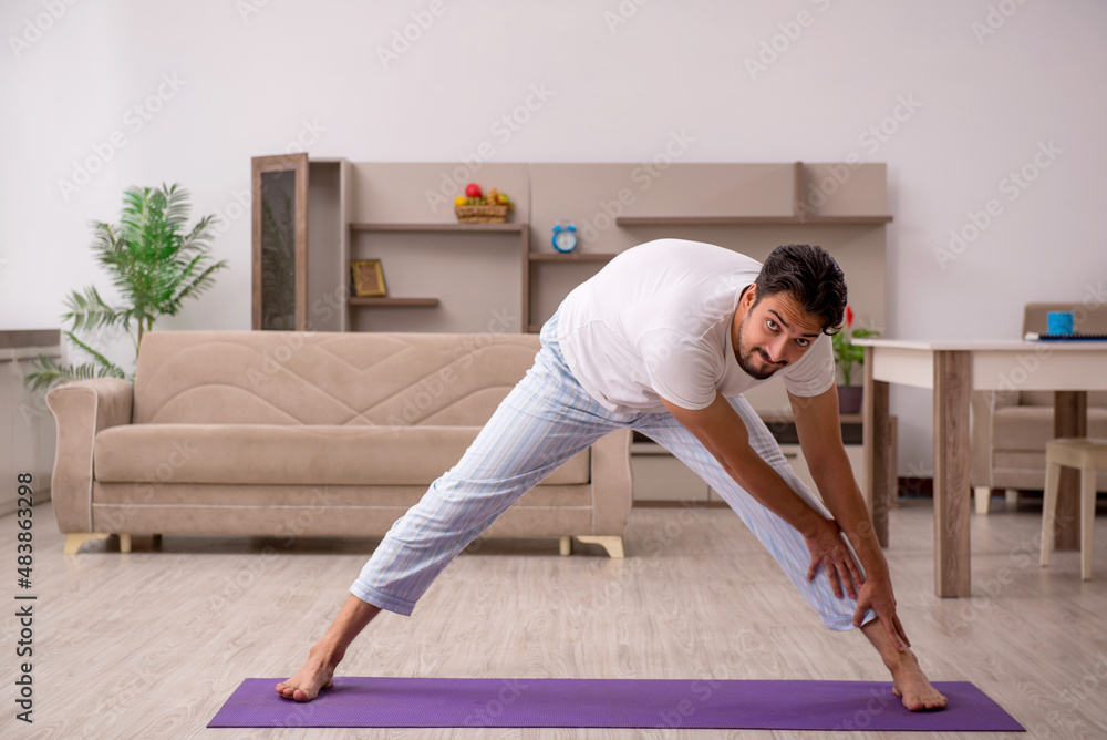 Young man doing sport exercises at home