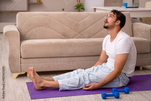 Young man doing sport exercises at home