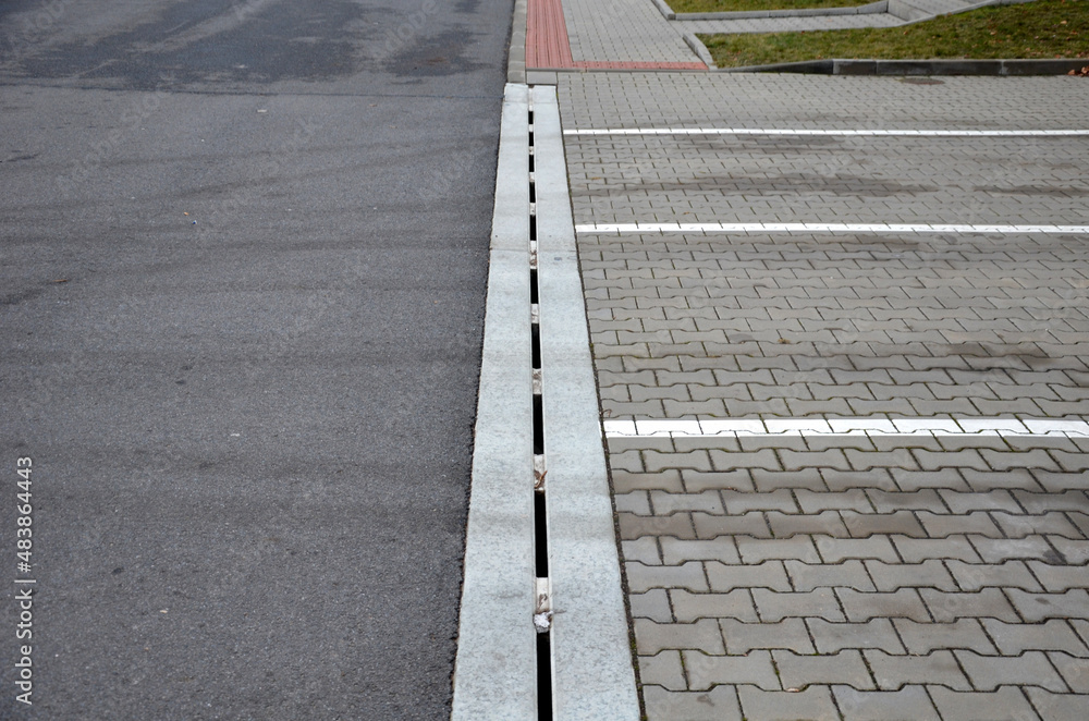 Fototapeta premium drainage element in interlocking paving concrete gutter with slotted drain from one piece of concrete can hold water from the parking lot along the entire length of the yard