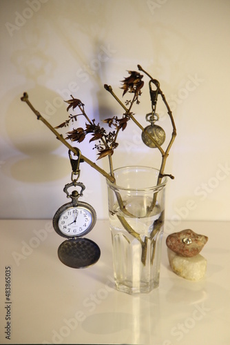 still life with a glass of water and old watch