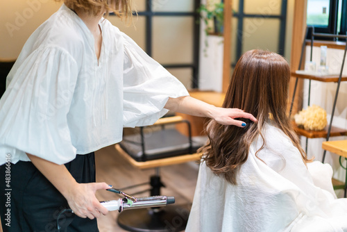 ヘアアイロンを使う美容師